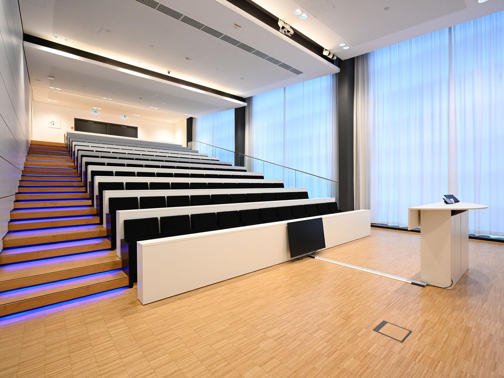 Interior view of the Abbe-Auditorium at the ZEISS Forum. This perspective shows the rows of seats from the entrance.