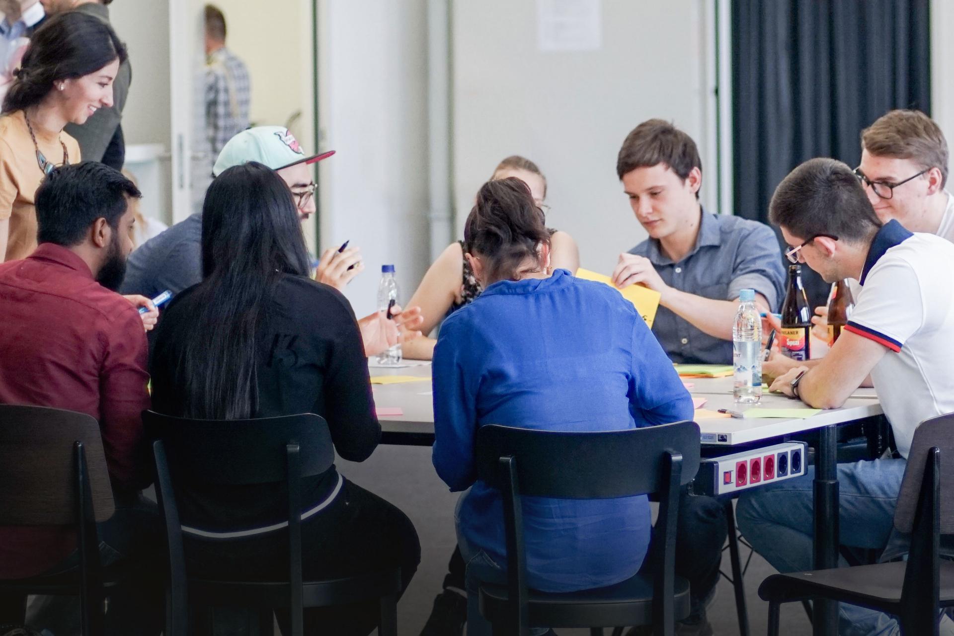 People sit around a table and talk to each other.