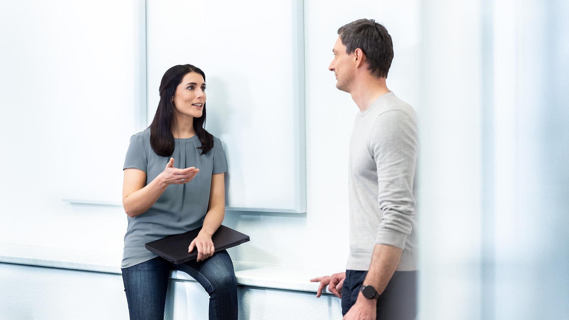 A woman talks to a man in an office environment
