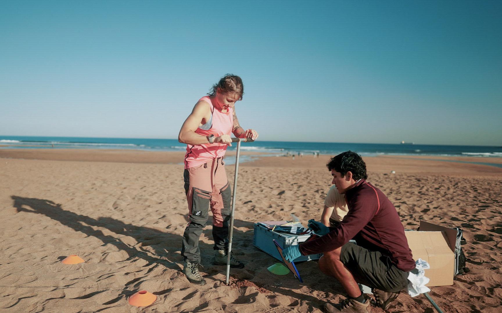 Three scientists take samples at the beach