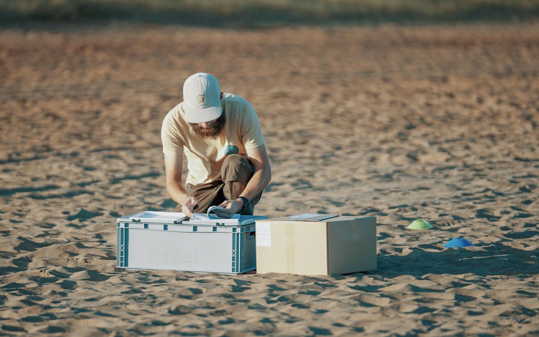 A scientist takes samples at the beach