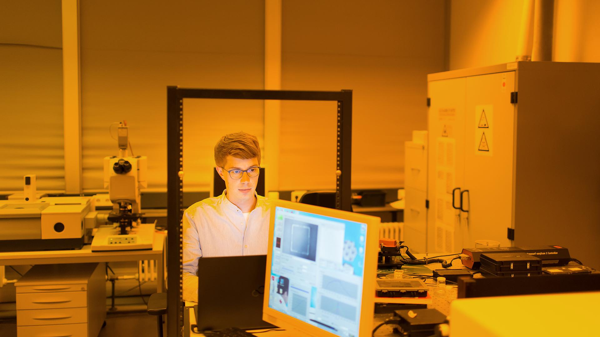 Mayer works on his laptop in the optics lab.