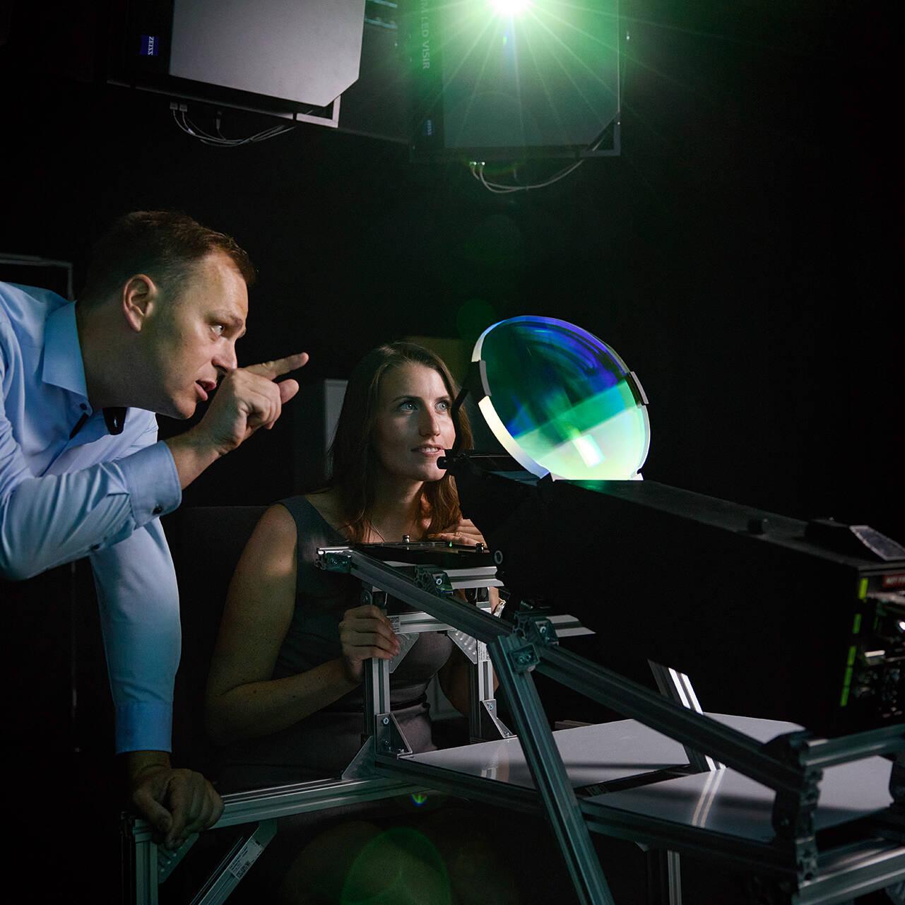 A man and a woman look through a shimmering green window – a head-up display. 