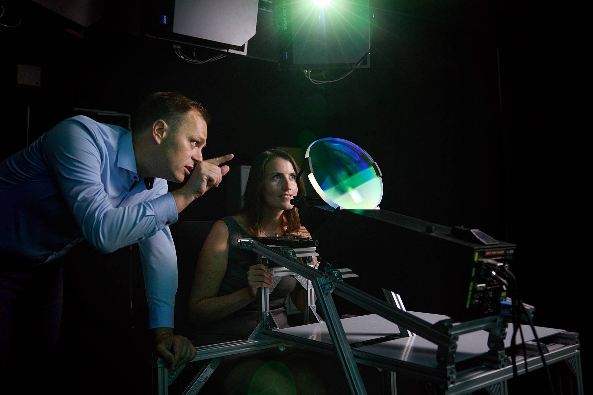 A man and a woman look through a shimmering green window – a head-up display.