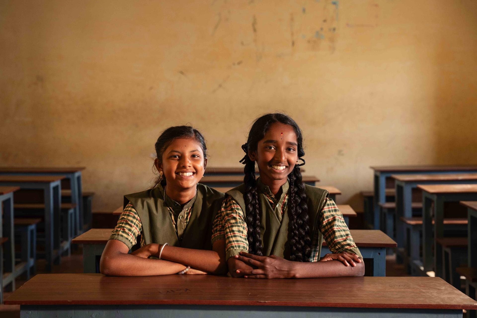 Two girls sitting on a school bench