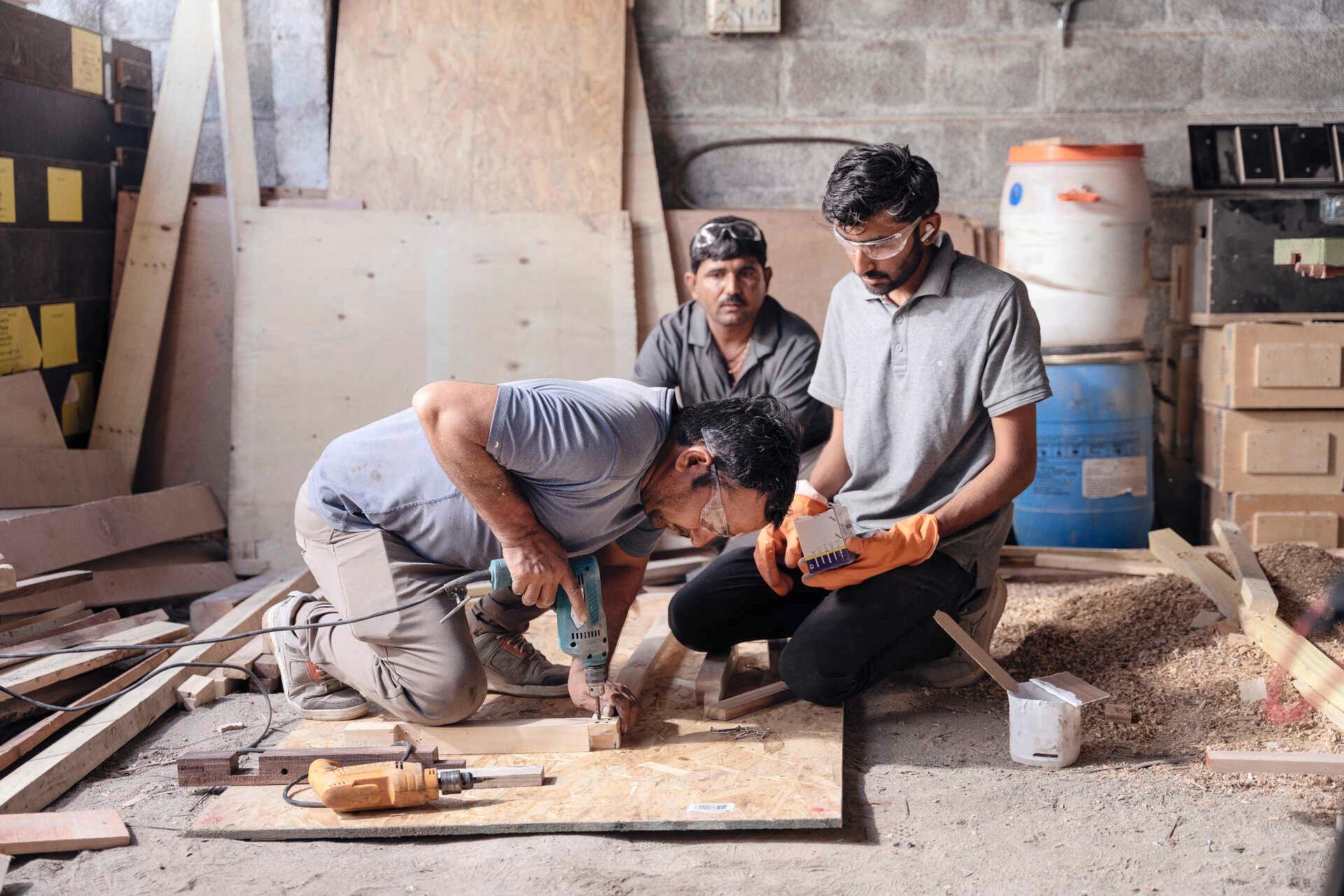 Sharma, Radia and a colleague are building new benches from discarded wooden crates