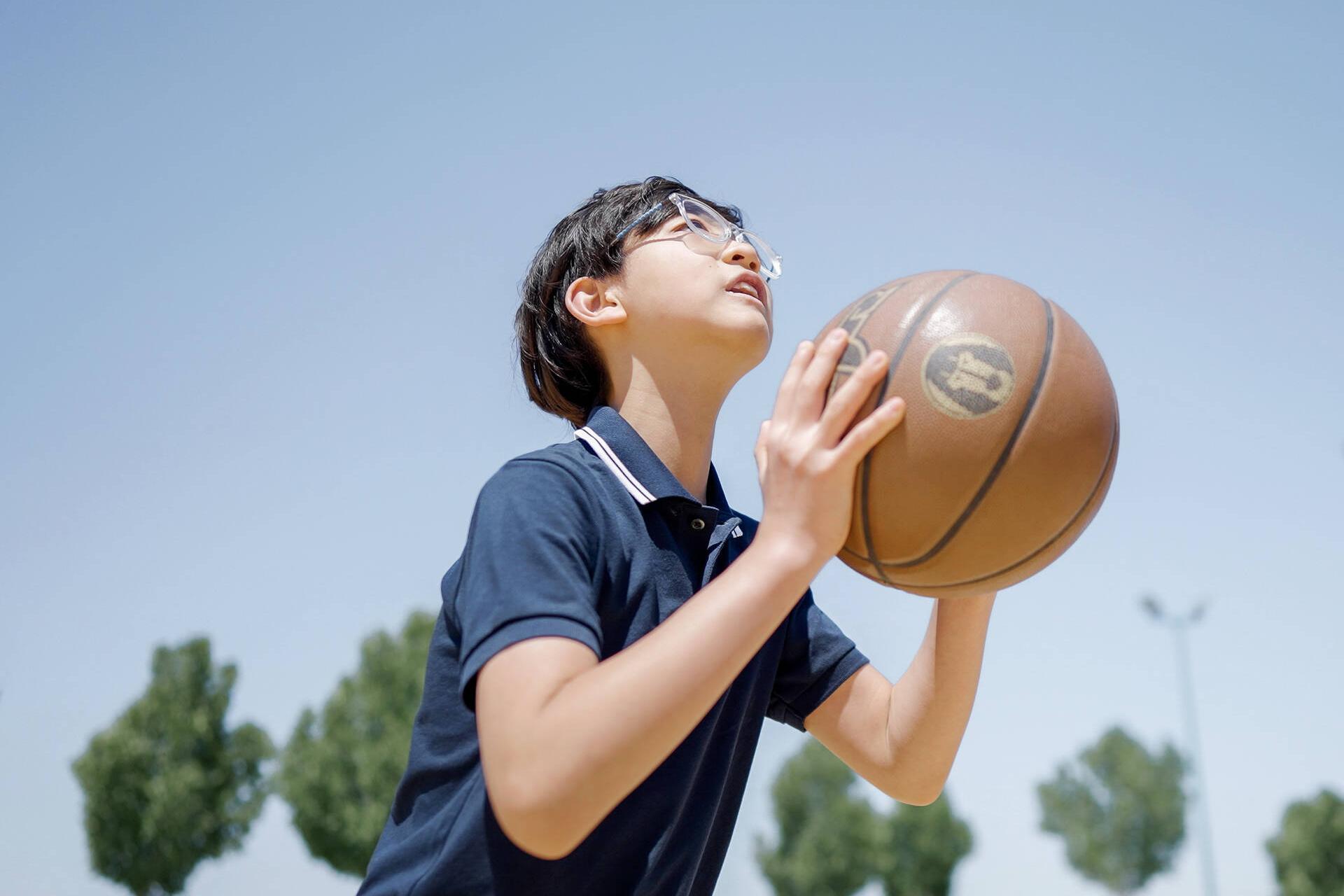 Aidan Zhong aiming a basketball throw on an outdoor court