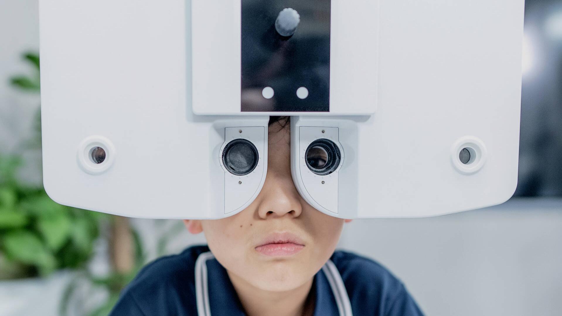 Aidan Zhong taking an eye test administered by Dr. Chen Xiaoqin