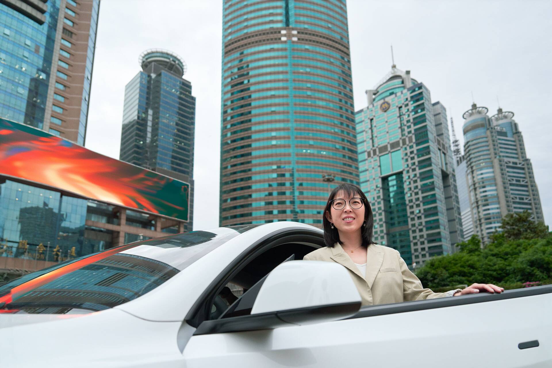 Yuqing Bai standing at her car in Shanghai