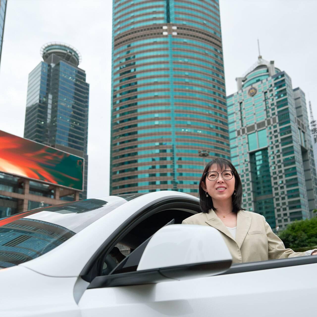 Yuqing Bai standing at her car in Shanghai