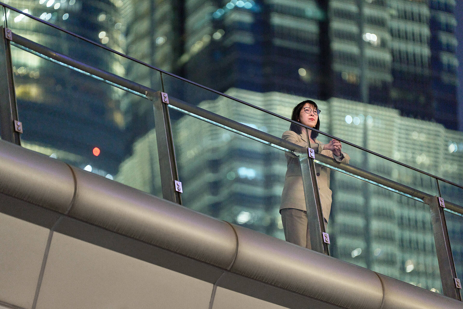 Yuqing Bai standing on a bridge overlooking the busy roads of Shanghai