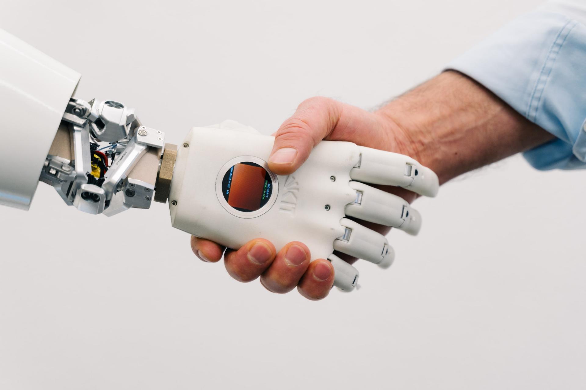 A robot shakes hands with a human