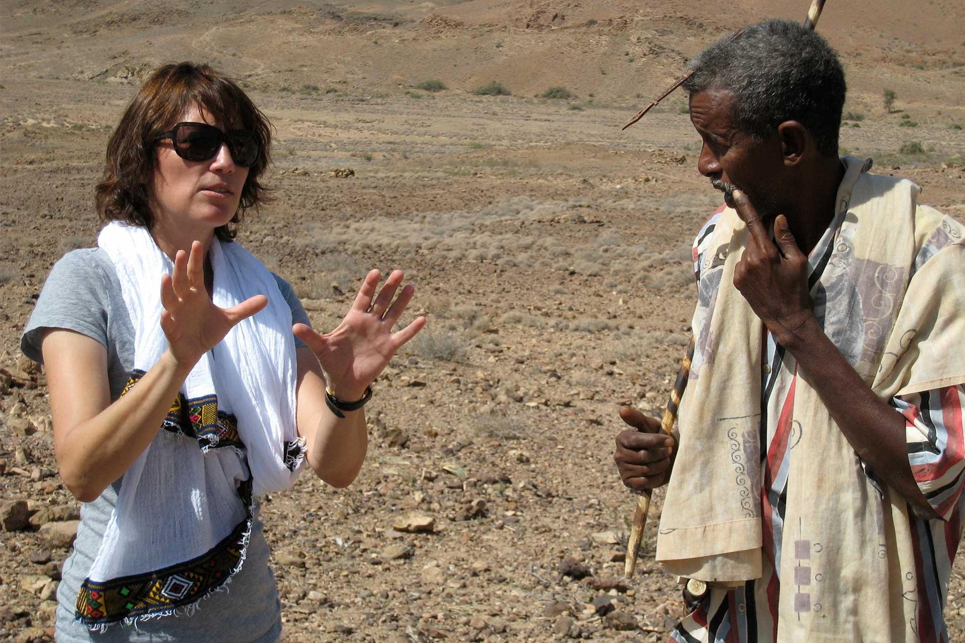 Sherry Hormann, German-American director, talking to man in dessert