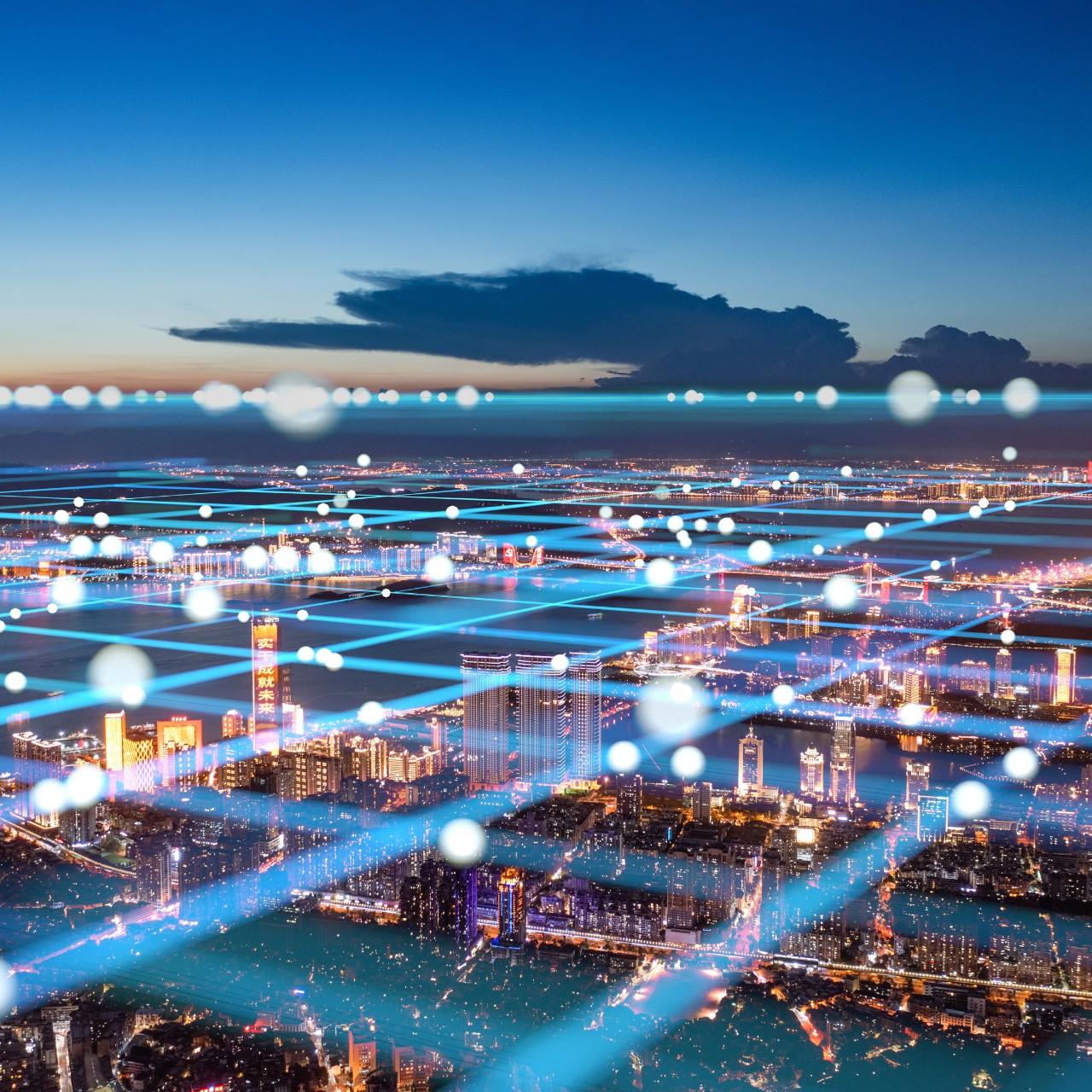 Dekoratives Bild einer beleuchteten Stadt bei Nacht mit symbolischen Lichtlinien für Vernetzung.