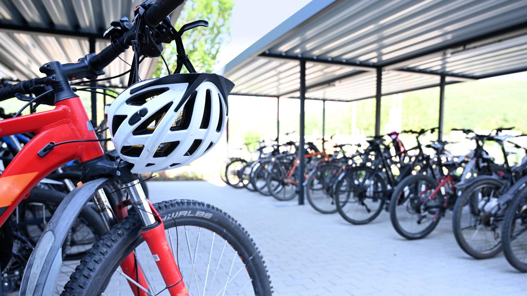 Ein Fahrrad-Parkplatz mit einem roten Fahrrad im Vordergrund.
