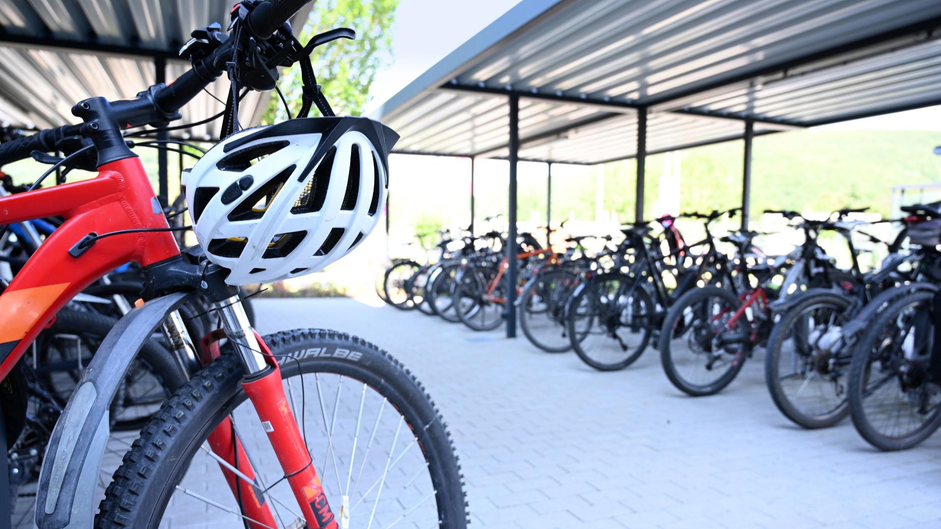 Ein Fahrrad-Parkplatz mit einem roten Fahrrad im Vordergrund.