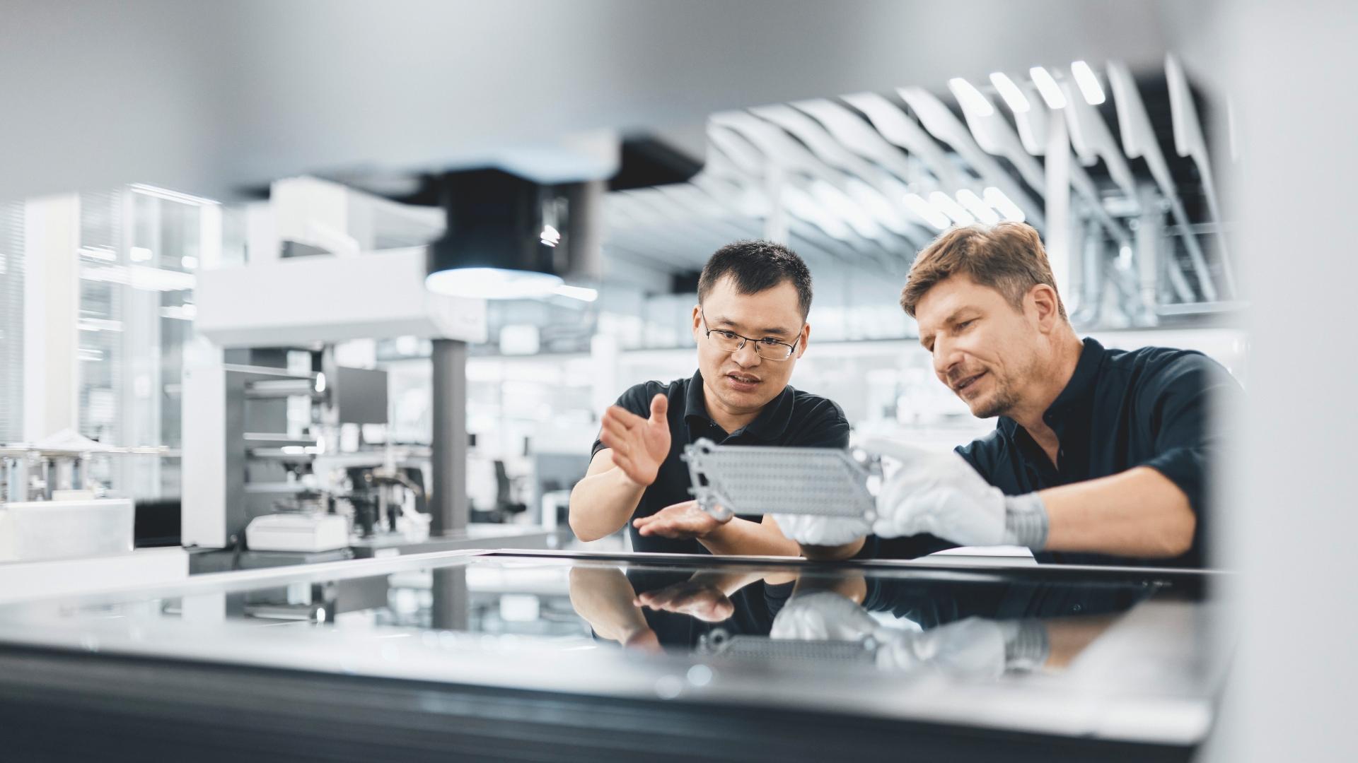 Zwei männliche Personen arbeiten mit ZEISS O-INSPECT duo in einer Fertigungsumgebung