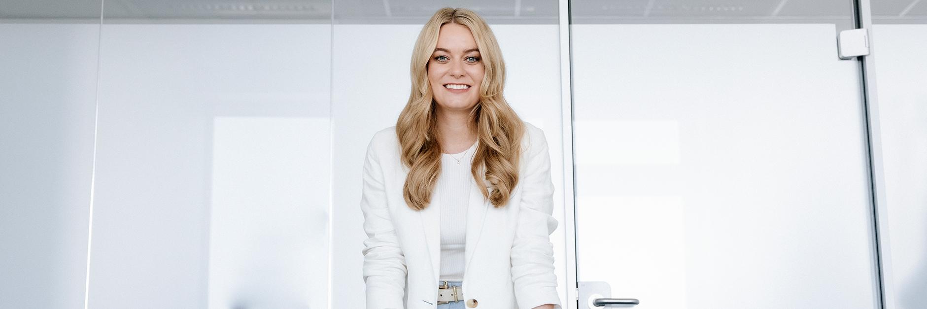 Liesa stands in a bright, modern office. She looks confidently at the camera