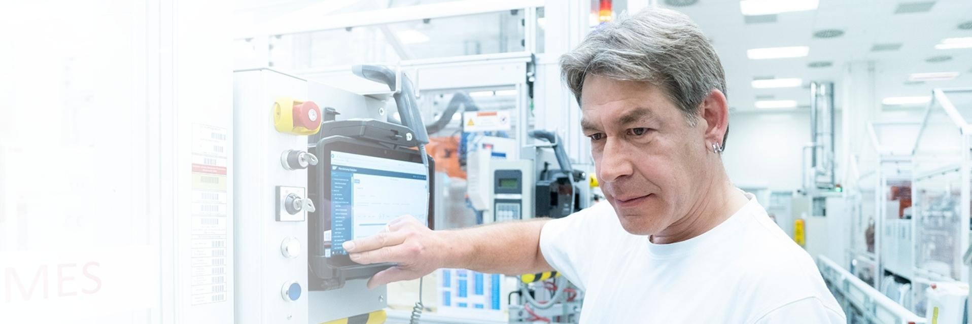 Wolfgang operates the touchscreen display in the production plant