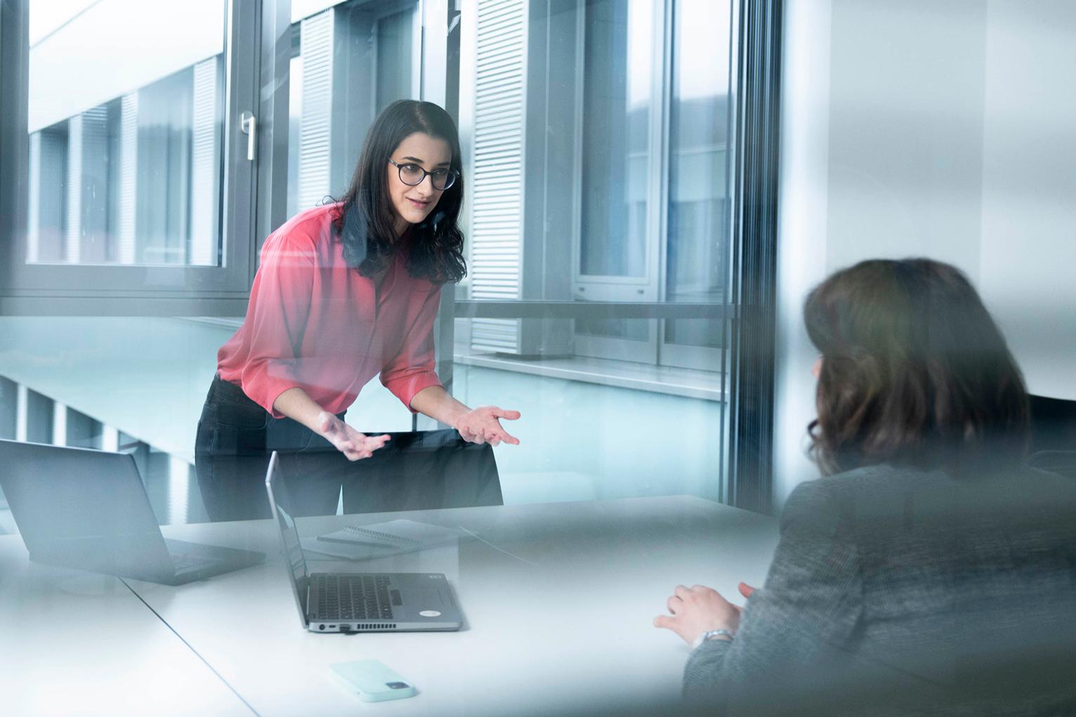 Camila chats to a female colleague in the office