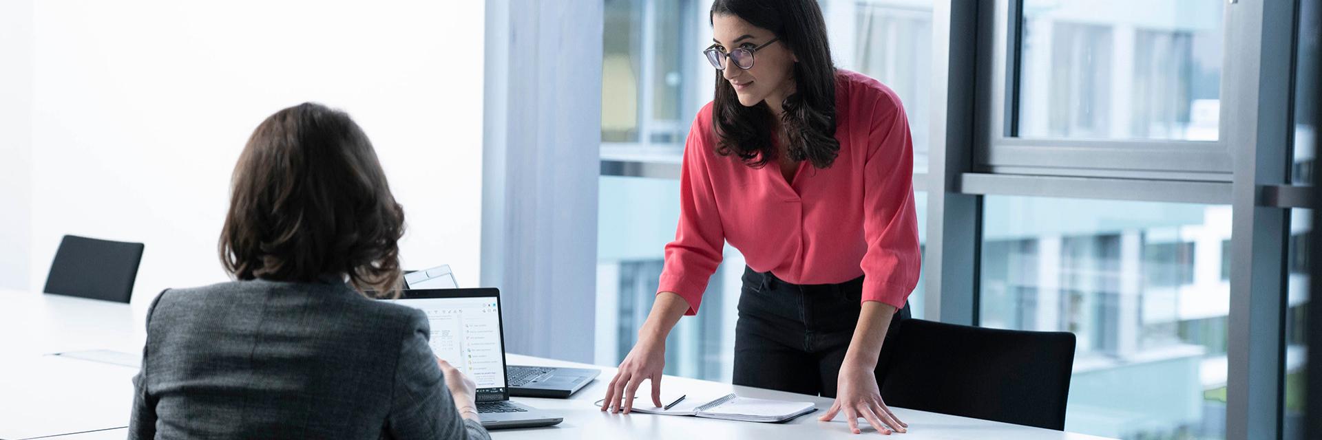 Camila chats to a female colleague in the office