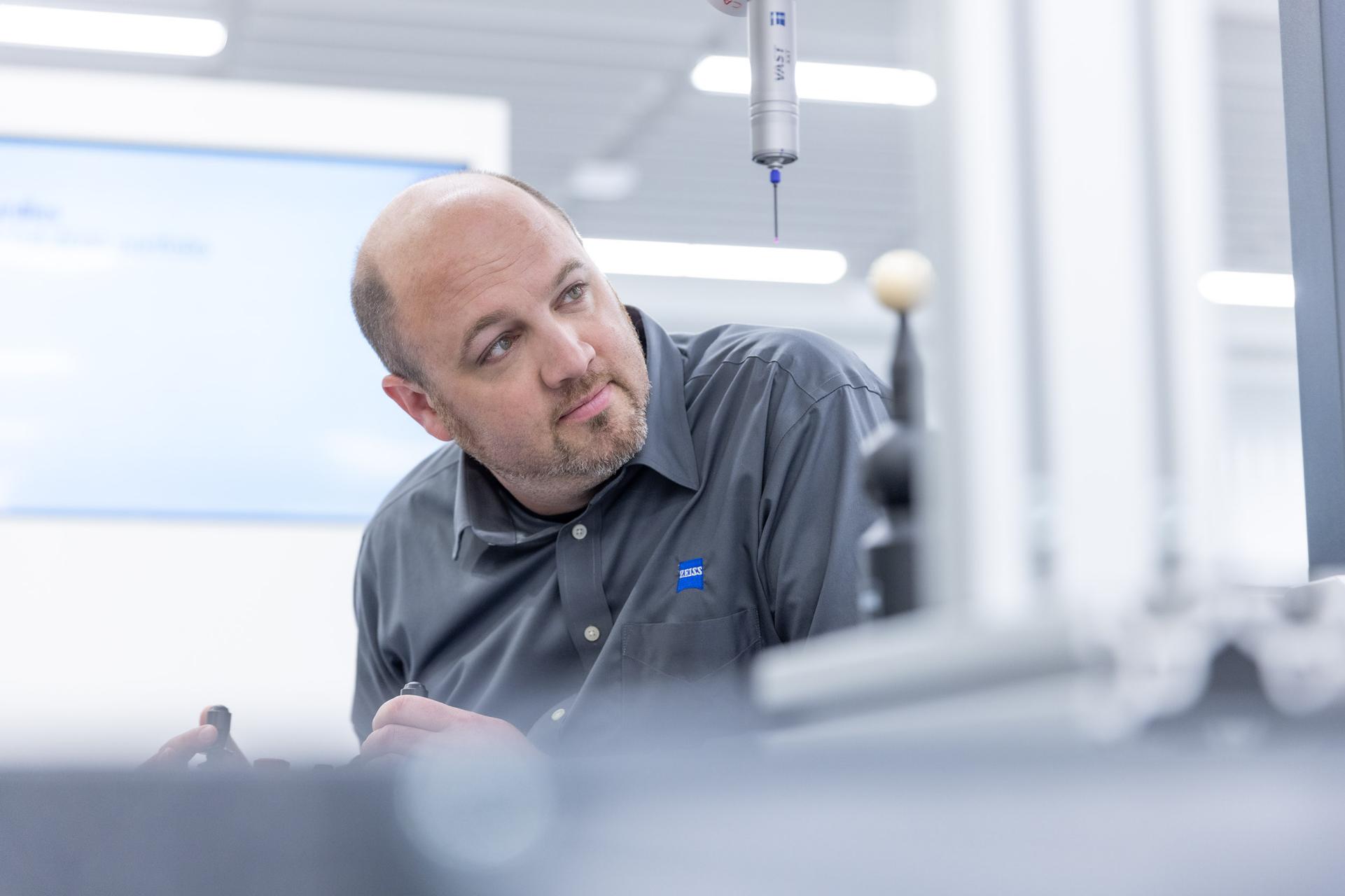 Jeff in einem Labor mit grauem Hemd arbeitet mit dem ZEISS VAST XXT taktilen Scanning Sensor.