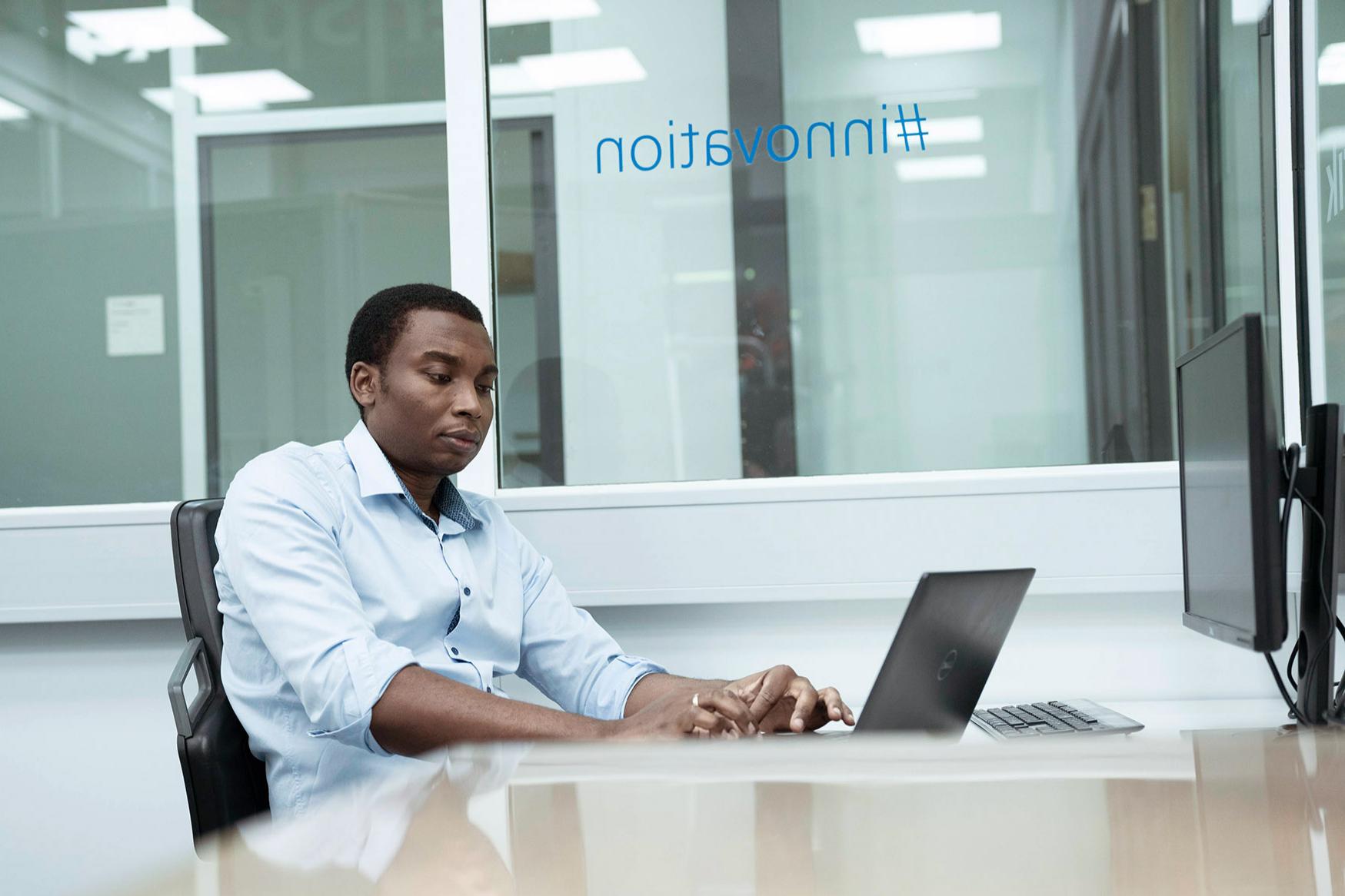 Marc arbeitet am Laptob im Büro