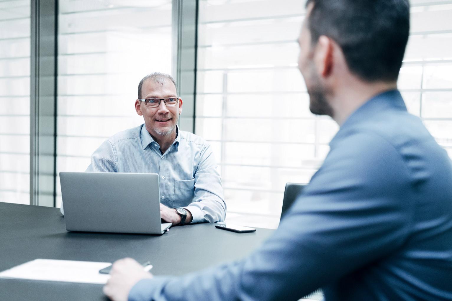 Martin chats to a male colleague in a conference room