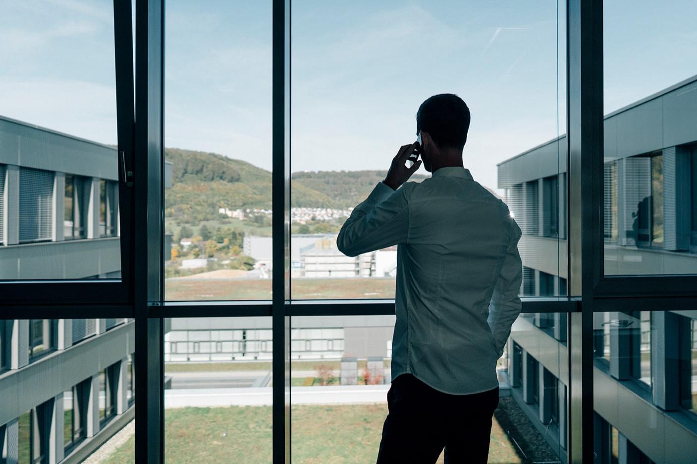 Philipp telefoniert im Büro und schaut aus dem Fenster