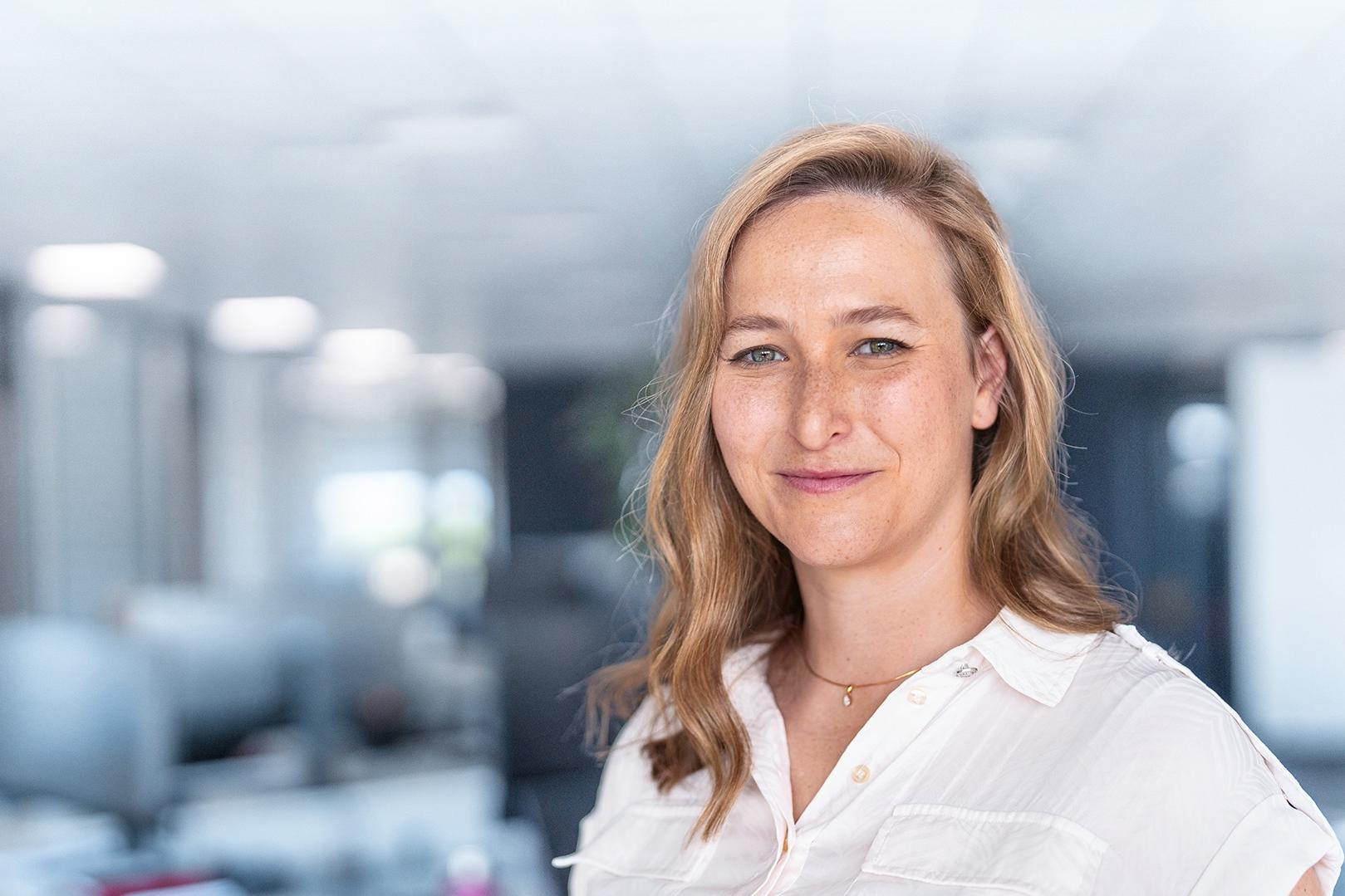 Zuzanna im Portrait blickt in ihrem ZEISS Büro gelassen lächelnd in den Raum.