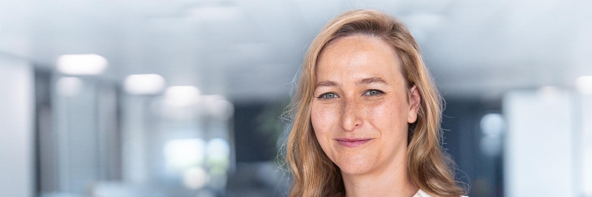 Zuzanna im Portrait blickt in ihrem Büro gelassen in den Raum.