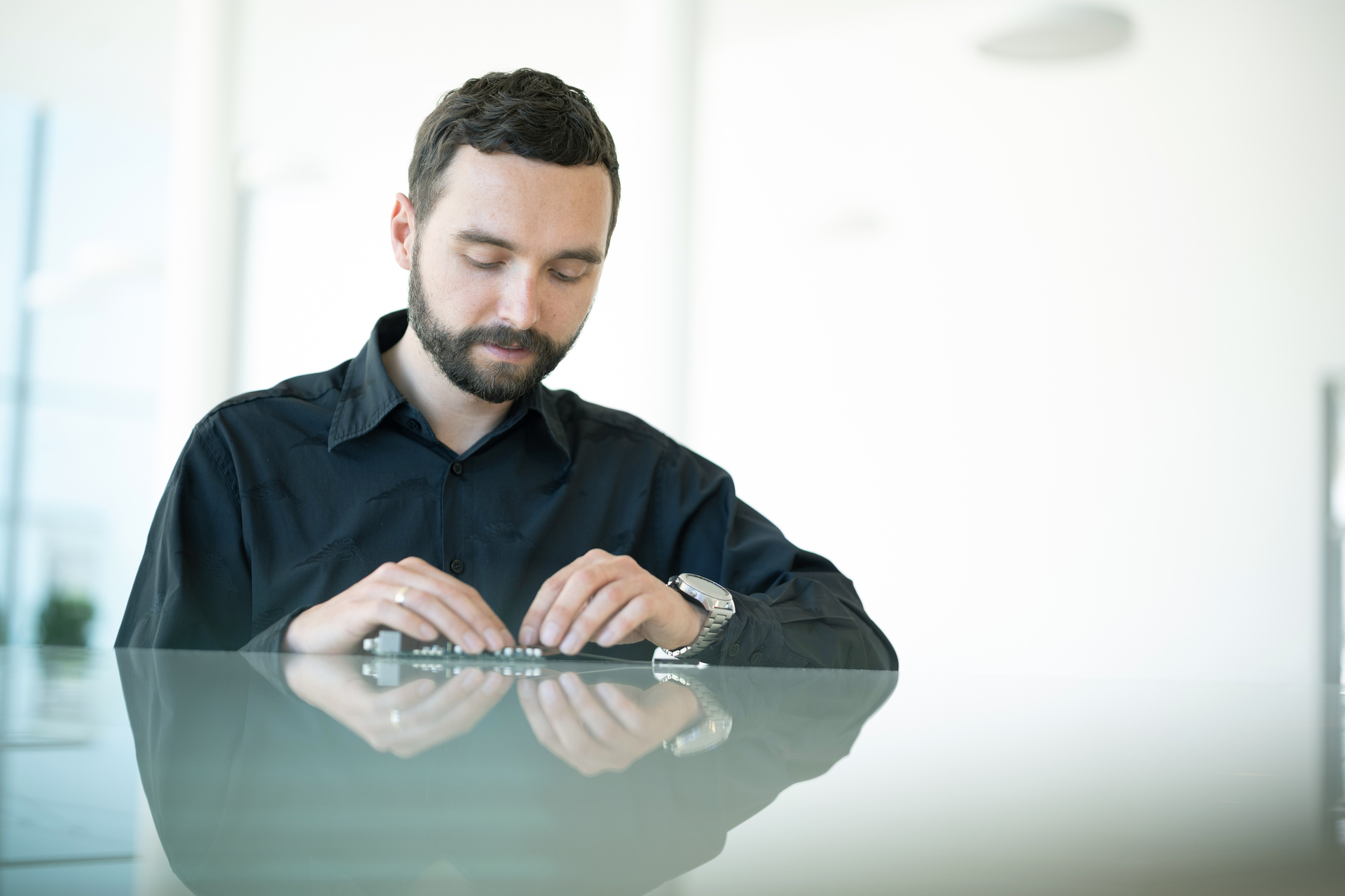 Ondrej sits at a desk and focuses on a hardware component