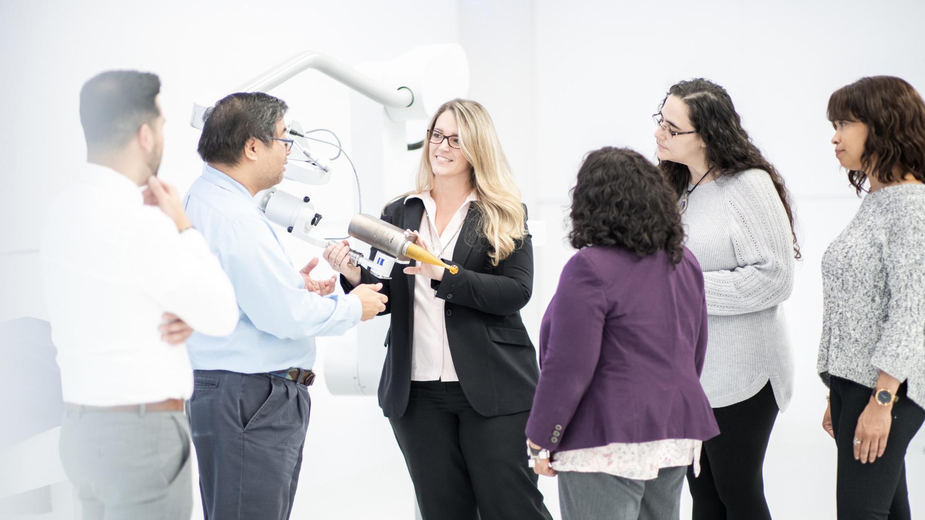 Ann mit einer Gruppe von Fachleuten, die das intraoperative Strahlentherapiesystem ZEISS INTRABEAM untersuchen.
