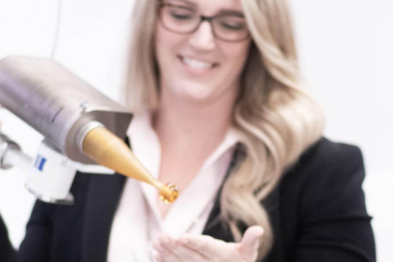 Ann hält den Spherical Applicator des intraoperativen Strahlentherapiesystems ZEISS INTRABEAM in der Hand, betrachtet das Gerät und lächelt