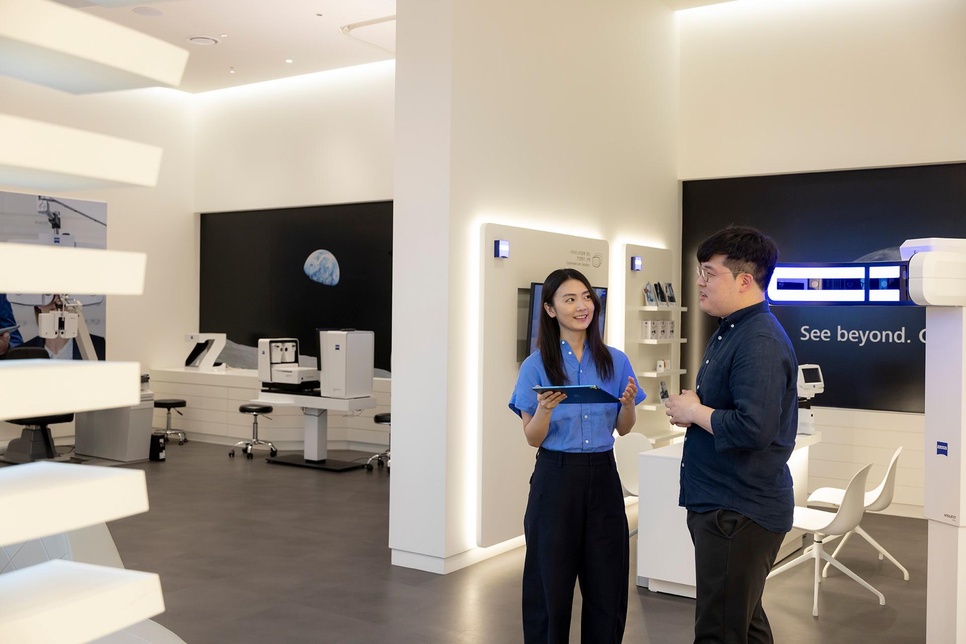 ZEISS Employee JiHye, standing in presenting room, talking to a colleague