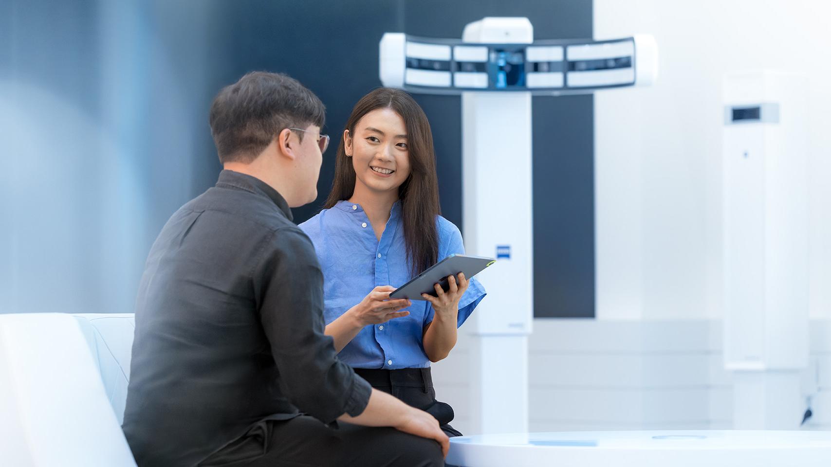 ZEISS Employee JiHye, standing in presenting room, talking to a colleague