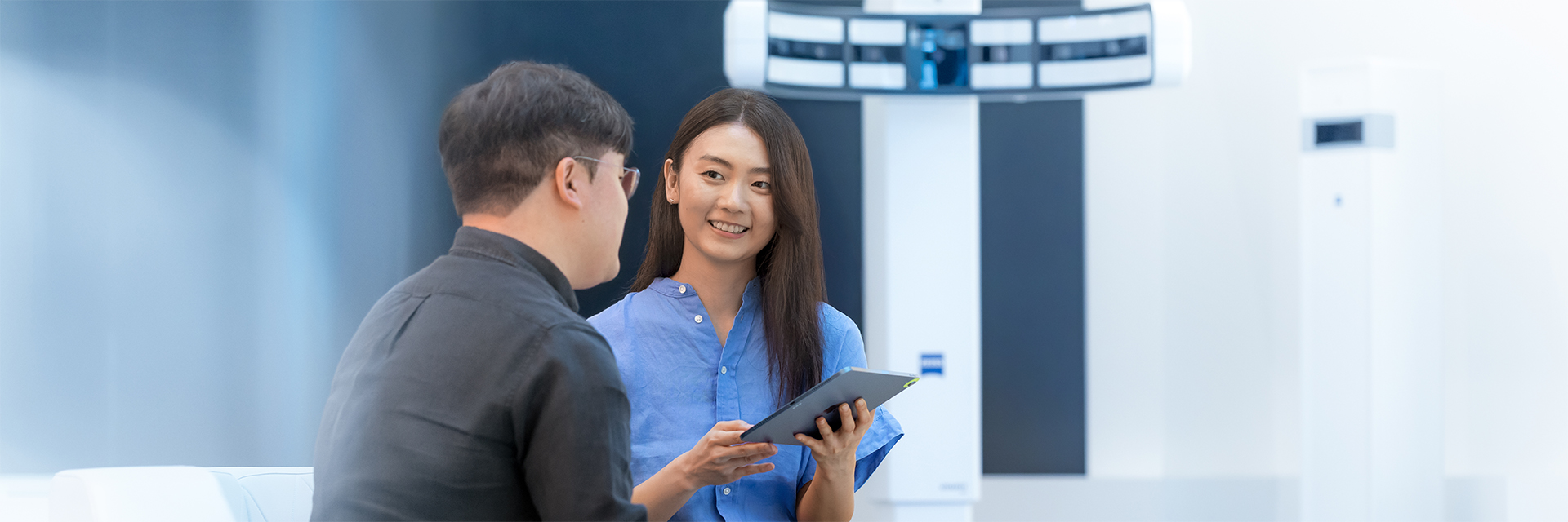 ZEISS Employee JiHye, standing in presenting room, talking to a colleague
