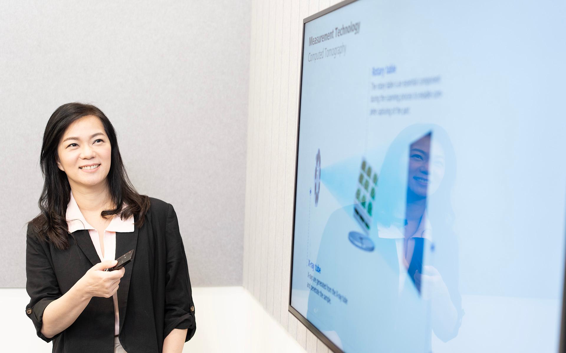 ZEISS employee Vivian presenting with the help of a TV screen.