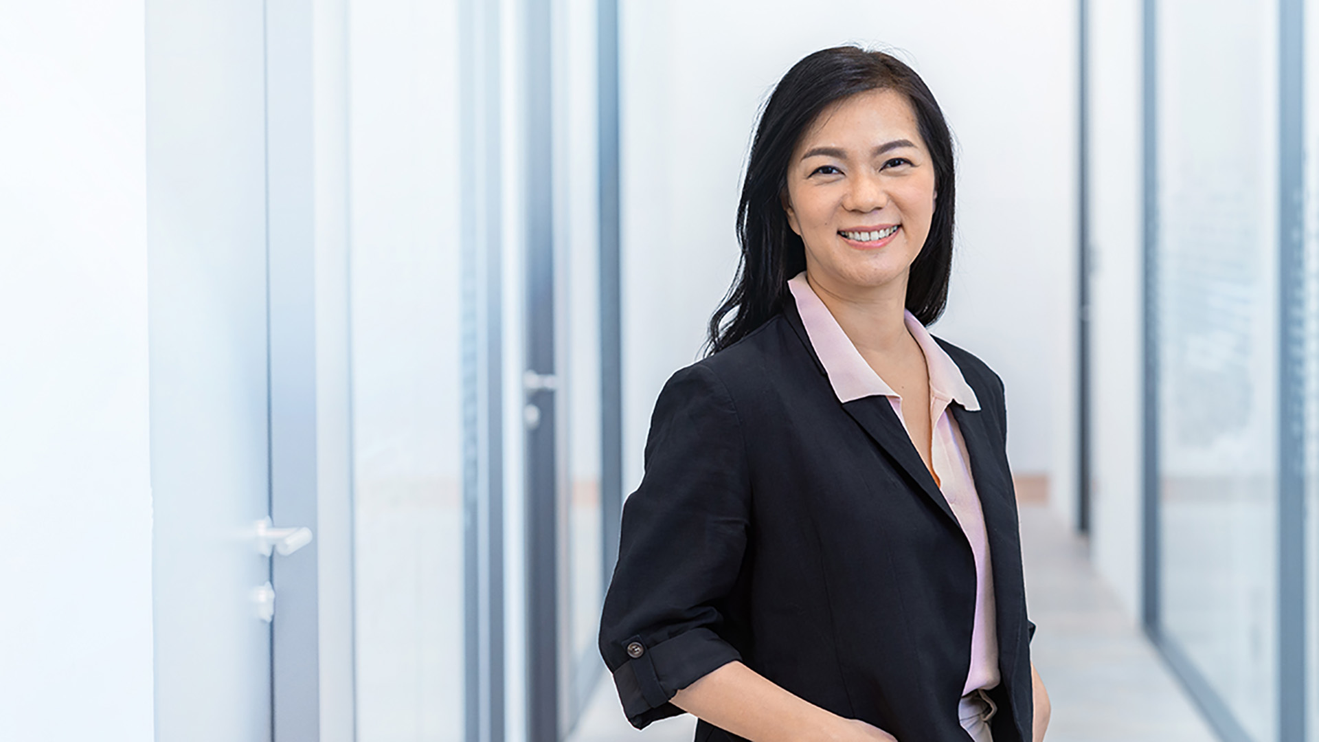 ZEISS Mitarbeiterin Vivian steht im Flur des Büros.