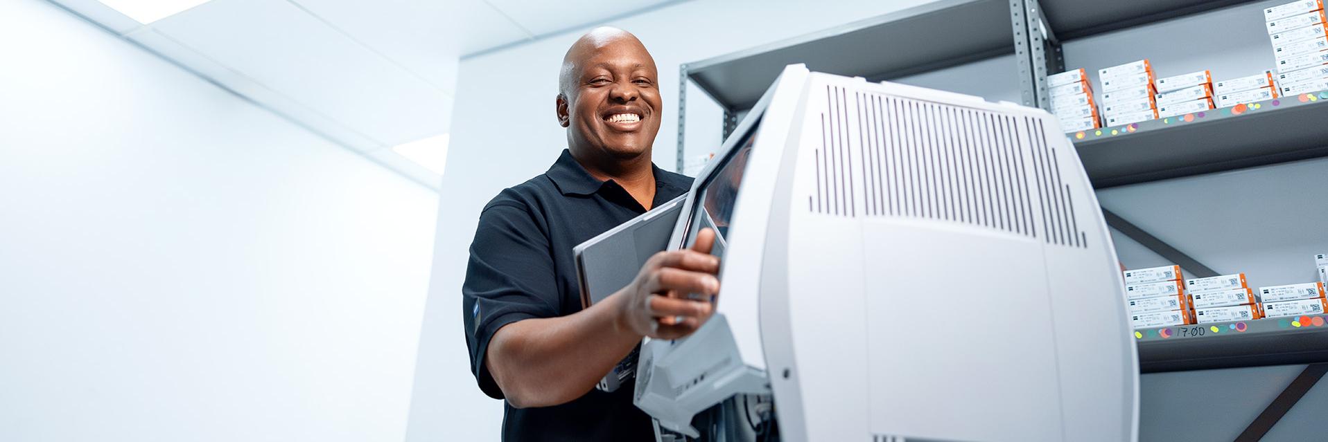 ZEISS field service Engineer Buyani grins broadly while repairing a ZEISS diagnostic device.