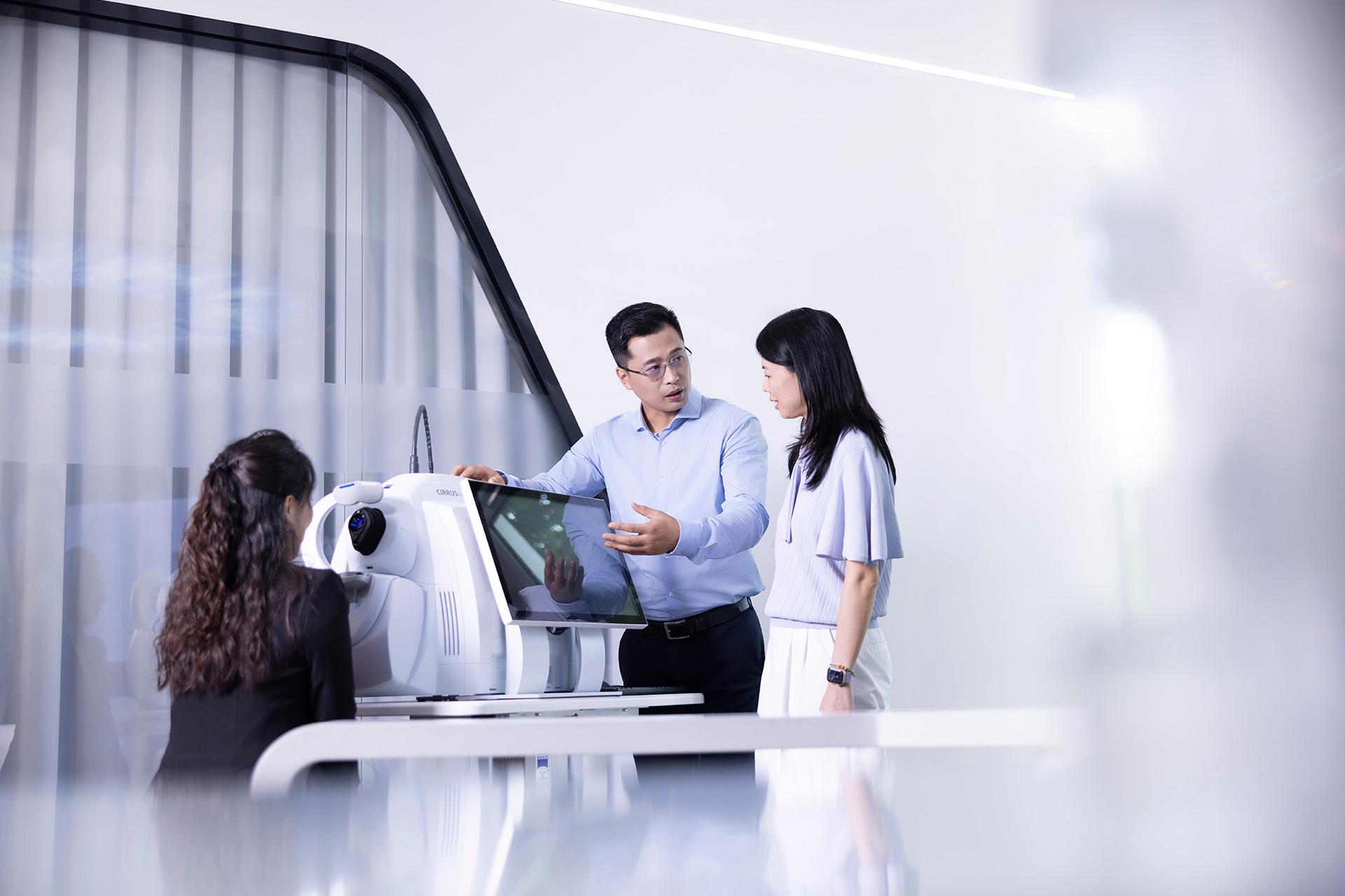 In his role as National Technical Support Manager, ZEISS employee Jun is explaining how a medical device works to a female colleague and building on her specialist knowledge.