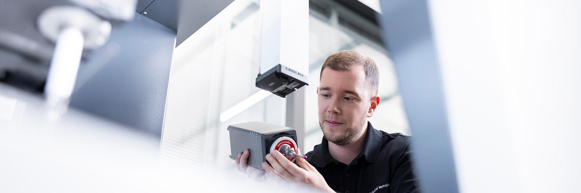 Marwin attaches a component to a ZEISS machine.