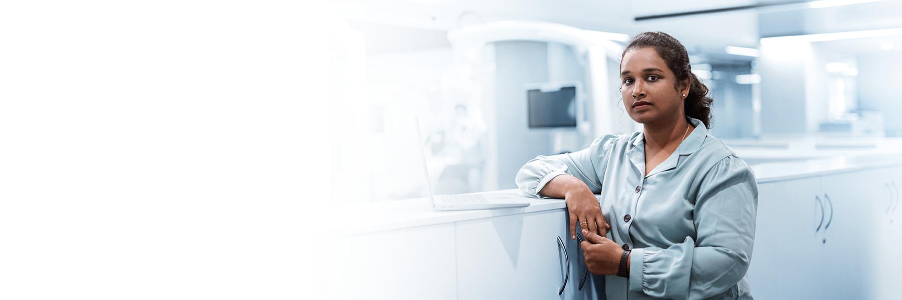 Das Bild zeigt Arbeitsräume von ZEISS in Indien Banglaore, mit einer indischen Mitarbeiterin in Office Outfit.