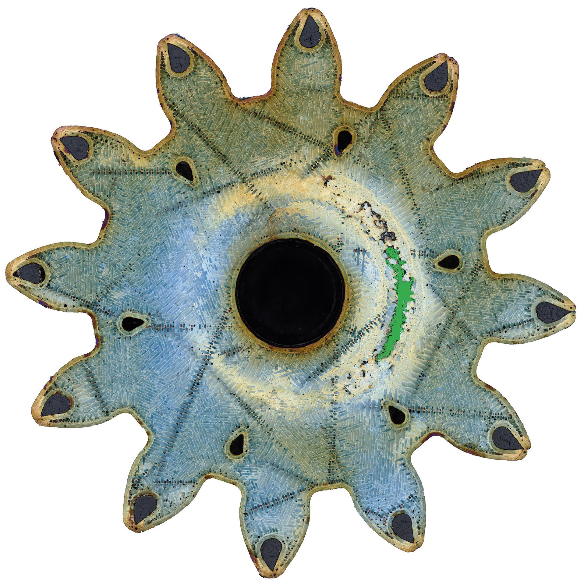 Close-up image of a star-shaped metallic component with a central black circular opening.