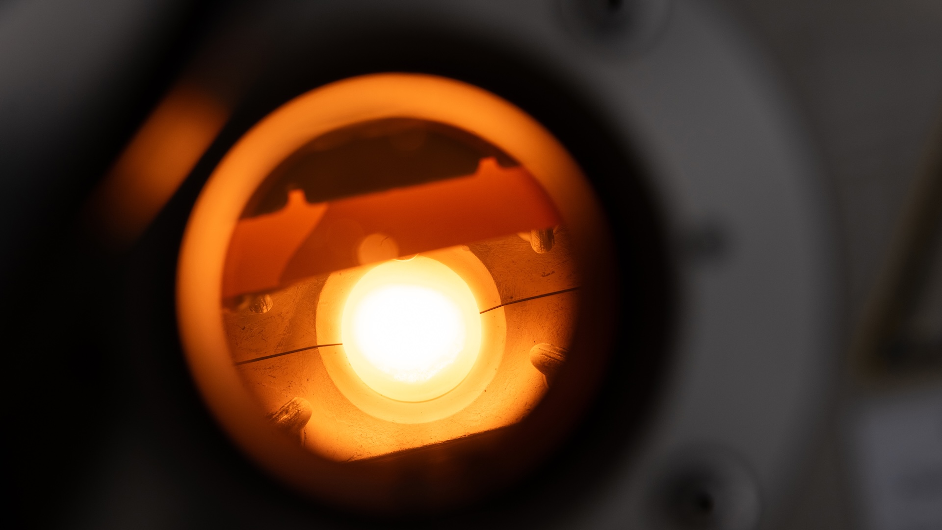 Close-up view of an illuminated optical component inside a scientific instrument, showcasing precision engineering by ZEISS.