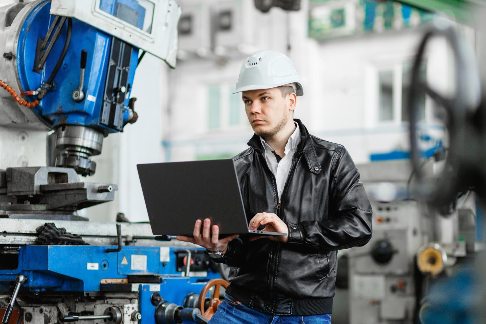 man with helmet and  a laptop in his hands