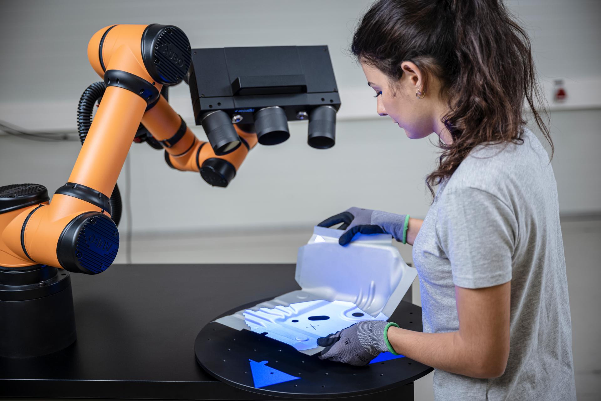 Woman measuring a part with a 3d scanner