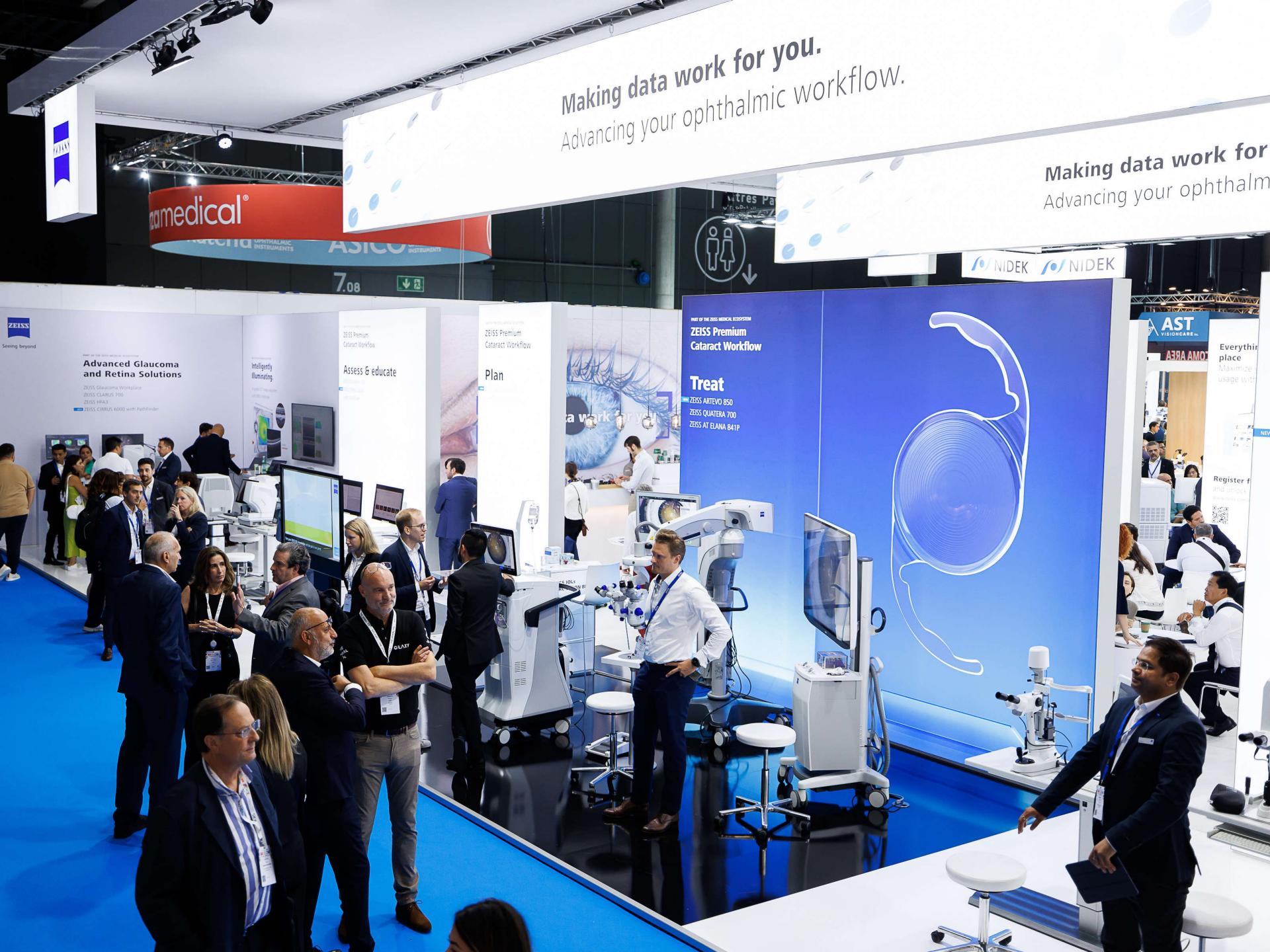 Visitors interact with advanced ophthalmic equipment and displays at the ZEISS exhibition booth during a professional medical trade show.
