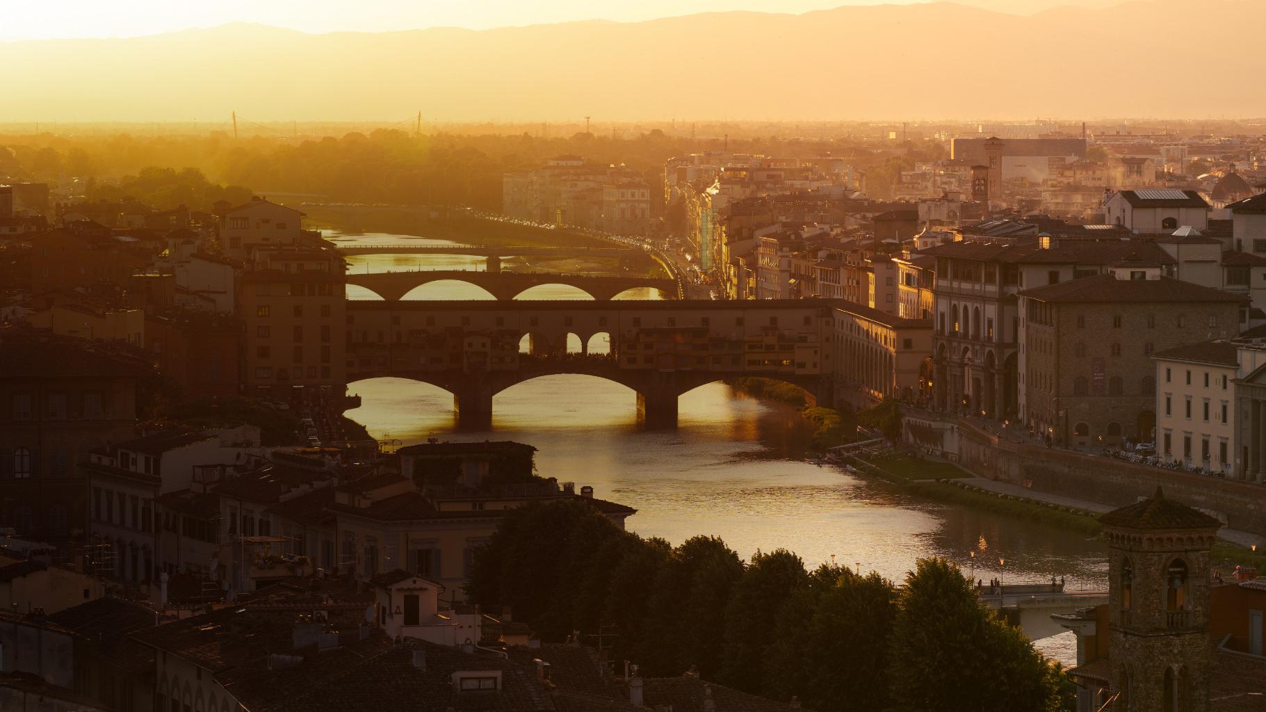 Arno River at sunset with Ponte Vecchio illuminated in Florence, Italy