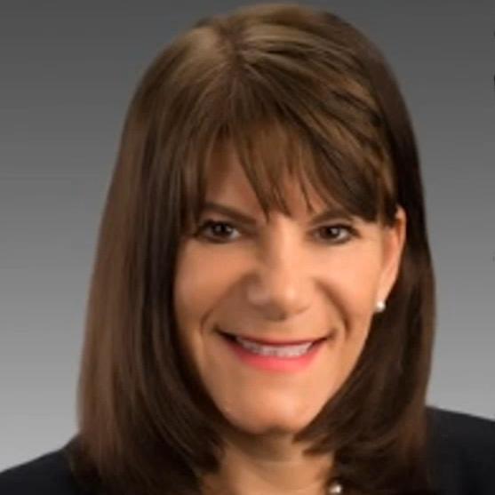 Professional woman in business attire smiling against a neutral gradient background, suitable for a ZEISS corporate profile.